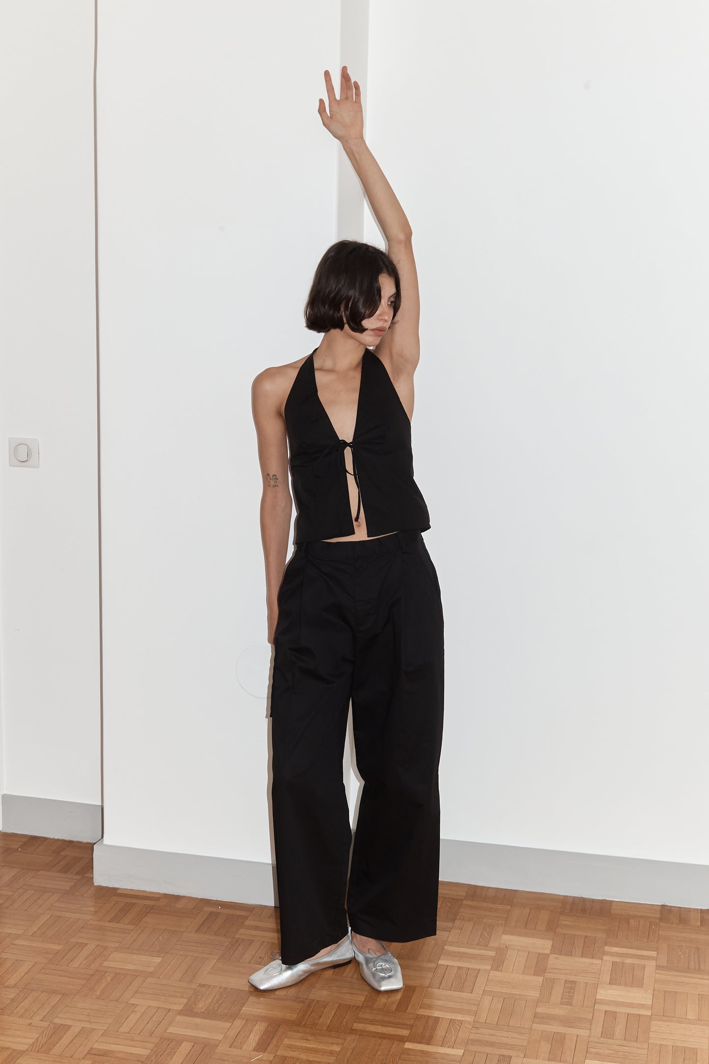 female model wears the open halter top top by Deiji Studios in black
top features open front with centre bust tie, halterneck tie and v neckline, bust seams for subtle shaping and shirred back
made from 100% GOTS certified organic cotton poplin
paired with a black cotton trouser