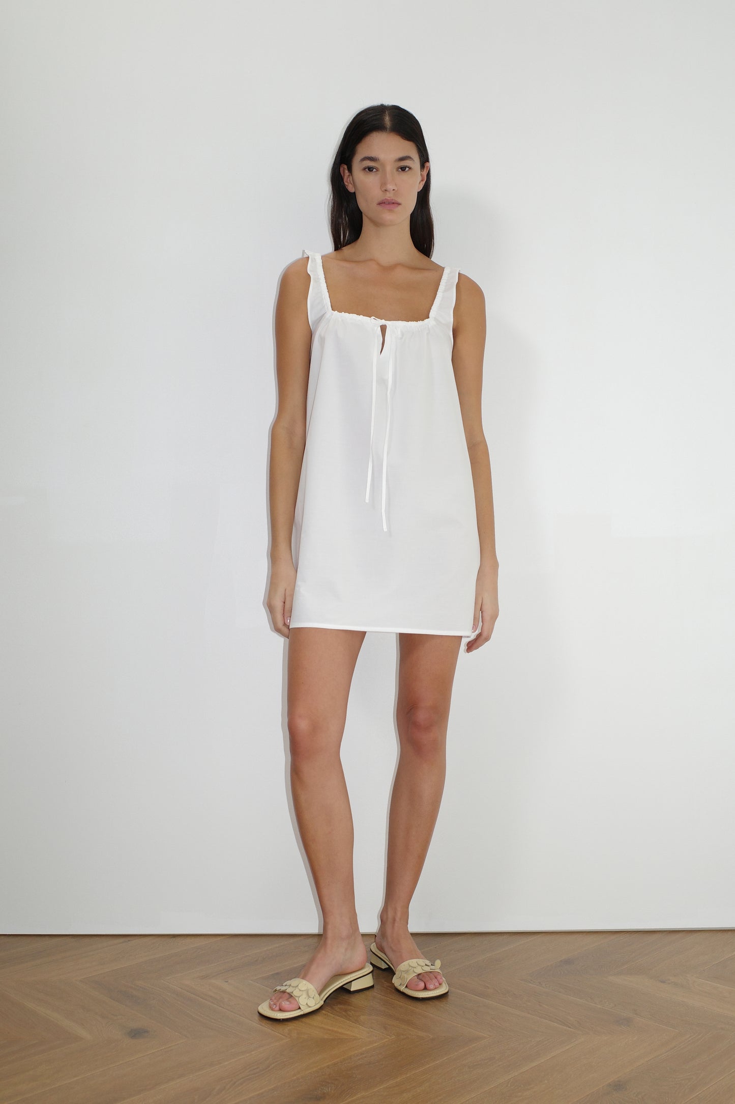 female model wears the bow dress in white exclusive to Deiji Studios
a crisp and lightweight mini-length dress features a flattering gathered square neckline with keyhole and tie front feature and side seam pockets
made from 100% GOTS certified organic cotton poplin
