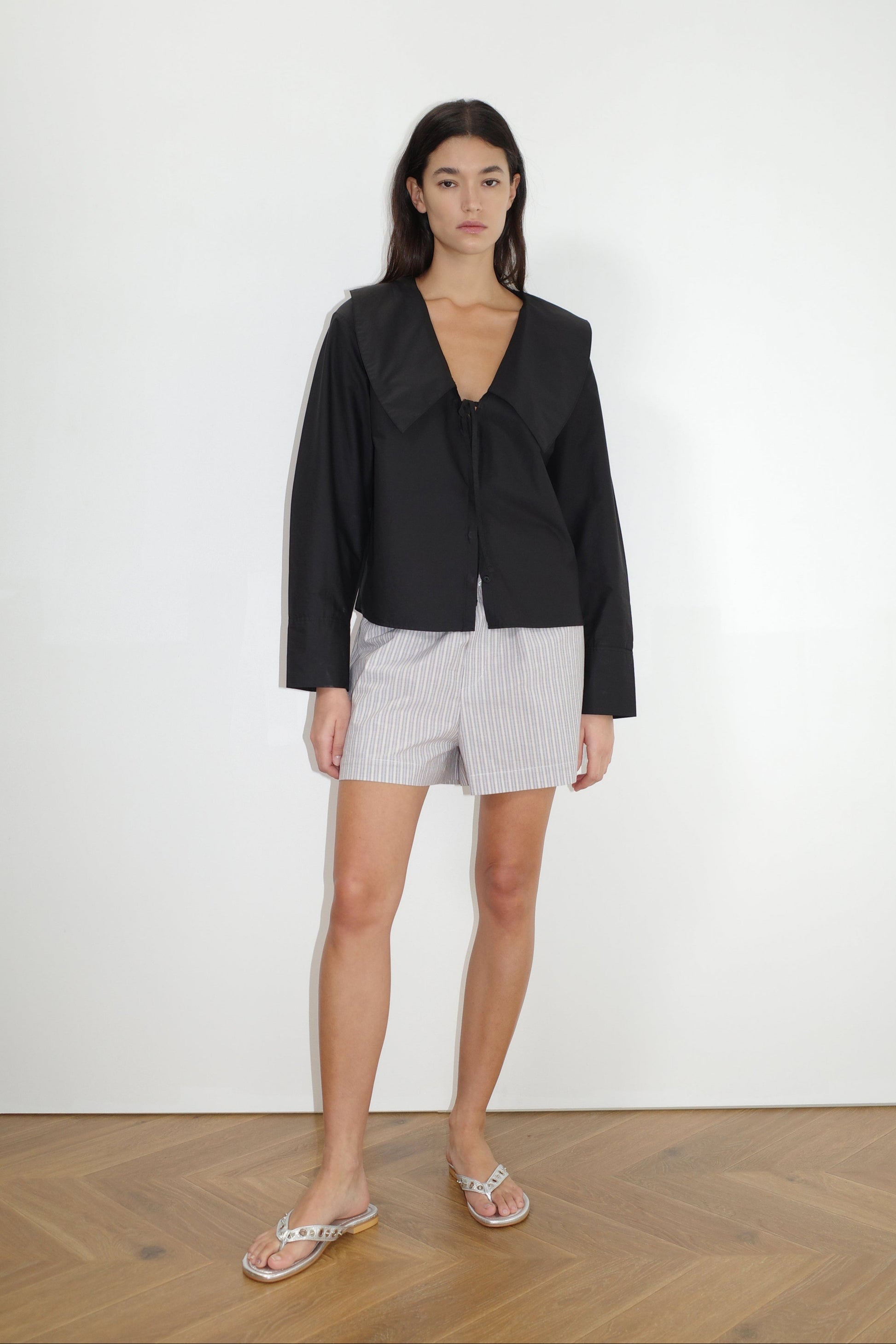 the collared tie shirt by Deiji Studios in black
a structured shirt features an oversized collar and cuff, tie at front collar opening, dropped shoulder and elongated sleeves in a boxy fit
made from 100% GOTS certified organic cotton poplin
paired with a blue stripe cotton boxer