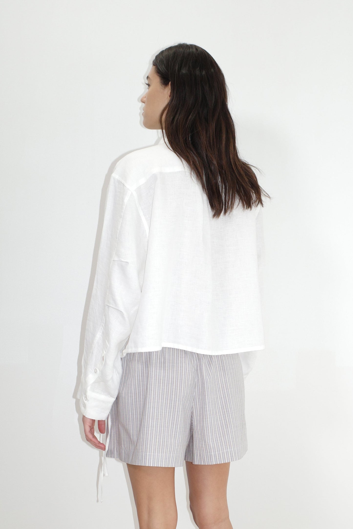 female model wears the hem shirt by Deiji Studios in white
a classic button up style shirt featuring a drawcord tie channel at bottom hem, dropped back yoke and dropped shoulder for a relaxed fit
made from 100% OEKO-TEX 100 certified and EU certified stone washed french linen
paired with boxer short in seas stripe
