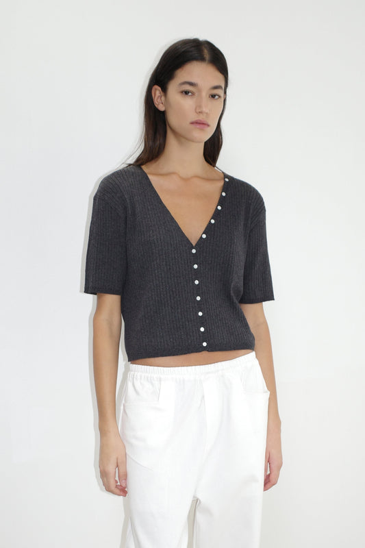 female model wears the one piece tee by Deiji Studios in coal
a fully fashioned ribbed knit features a flattering deep v neckline, mid length sleeve and button front design feature in a relaxed fit
made from 95% BCI cotton and 5% cashmere
paired with a white cotton trouser