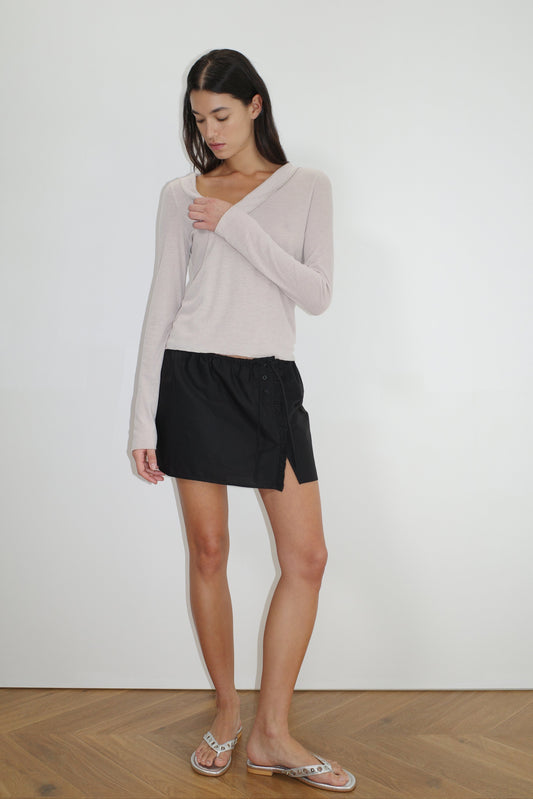 female model wears the cross collar top by Deiji Studios in shell
a sheer fine knit long sleeved top with asymmetric collared neckline, featuring baby locked finishes and a relaxed fit
made from a responsible blend of 85% Recycled Polyester and 15% Viscose
paired with a black cotton skirt