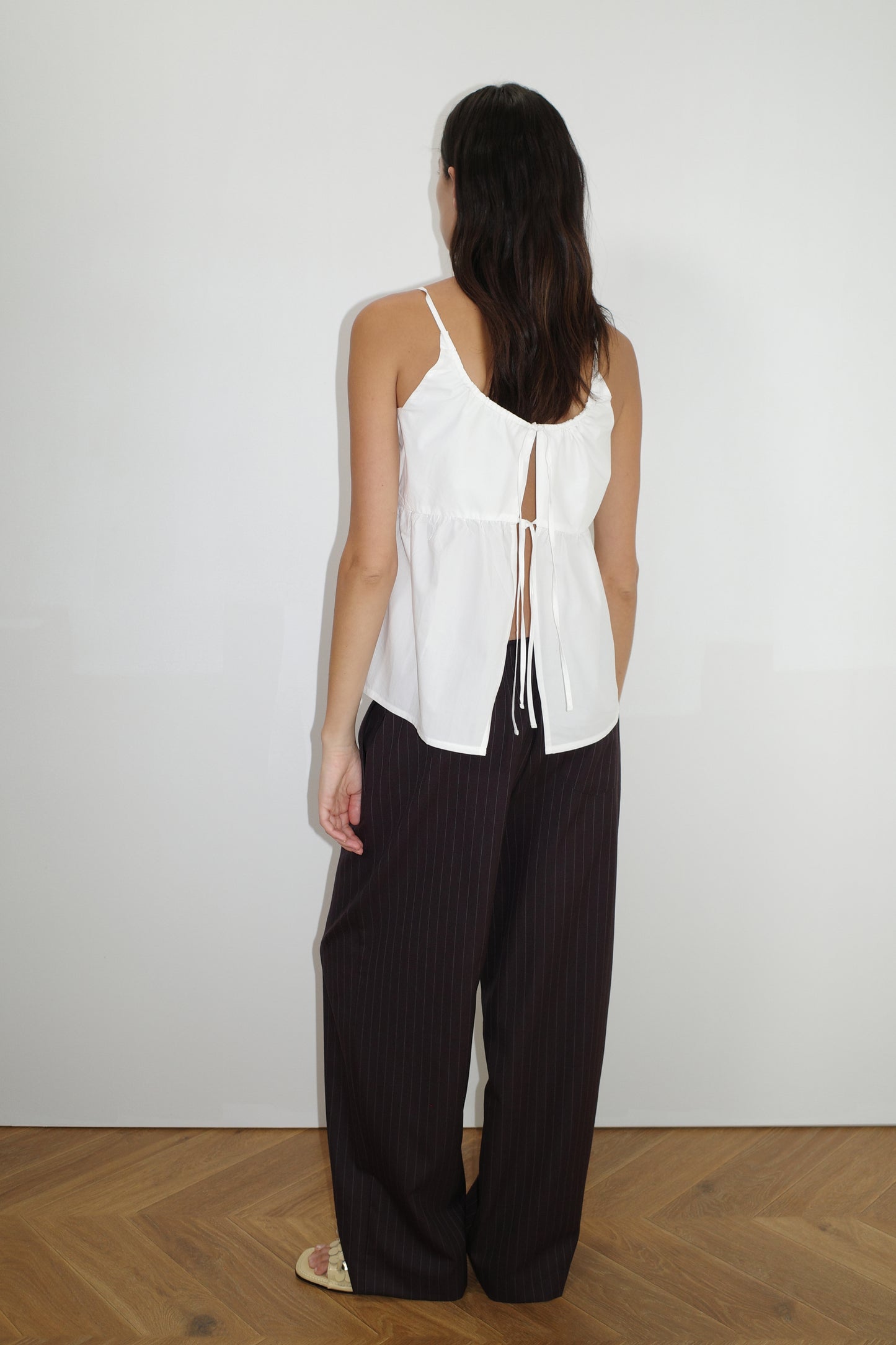 female model wears the double tie top by Deiji Studios in white
reversible relaxed top featuring flattering curved neckline and two tie detail at front, drawcord casing feature and fine straps.
made from 100% organic cotton poplin
paired with a pinstripe licorice wool pant