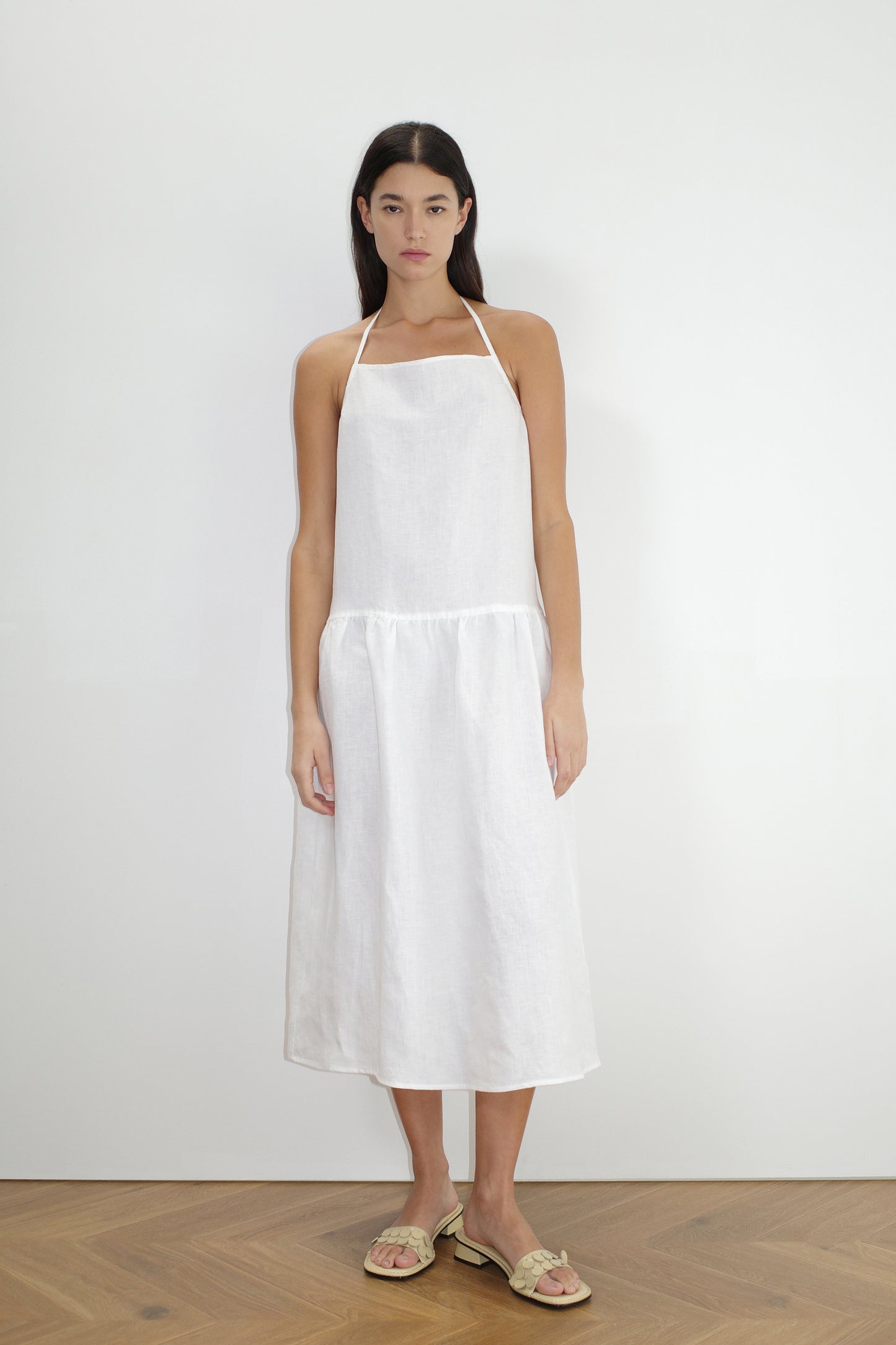 female model wears the gathered halter dress by Deiji Studios in white
a relaxed mid-length dress featuring a drop waist with soft gathered skirt. gathering under the armholes and adjusttable tie straps at back
crafted from 100% OEKO-TEX 100 certified and EU-certified stone-washed french linen, offering a luxurious and breathable feel