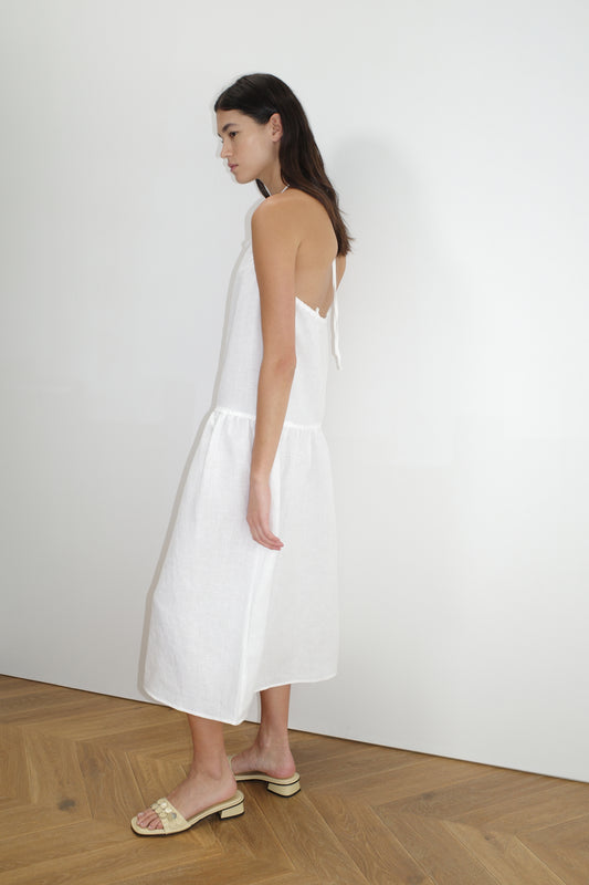 female model wears the gathered halter dress by Deiji Studios in white
a relaxed mid-length dress featuring a drop waist with soft gathered skirt. gathering under the armholes and adjusttable tie straps at back
crafted from 100% OEKO-TEX 100 certified and EU-certified stone-washed french linen, offering a luxurious and breathable feel