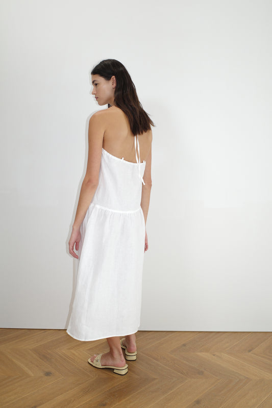 female model wears the gathered halter dress by Deiji Studios in white
a relaxed mid-length dress featuring a drop waist with soft gathered skirt. gathering under the armholes and adjusttable tie straps at back
crafted from 100% OEKO-TEX 100 certified and EU-certified stone-washed french linen, offering a luxurious and breathable feel
