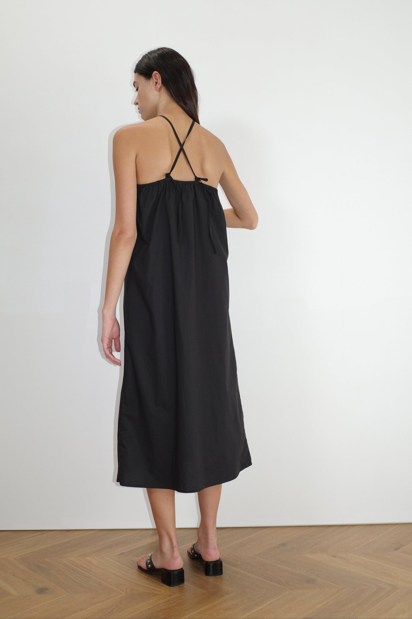 female model wears the keyhole midi dress by Deiji Studios in black
relaxed longline dress in a mid-length features a soft elastic neckline, self fabric adjustable ties as back and crossover shoulder straps
made from 100% organic cotton poplin
