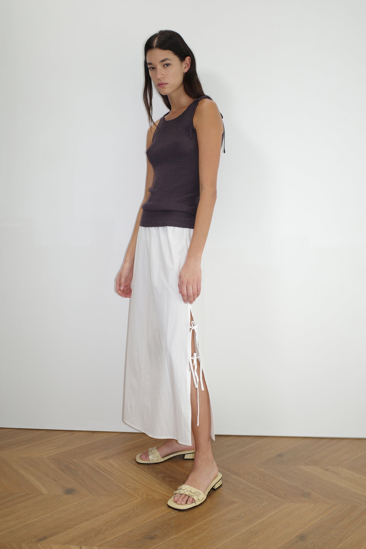 female model wears the one tie top by Deiji Studios in eggplant
a minimalist, fully fashioned tank-style knit top featuring asymmetrical tie strap design made with a lightweight ribbed texture
made from 90% eco-viscose and 10% linen
paired with a white cotton skirt
