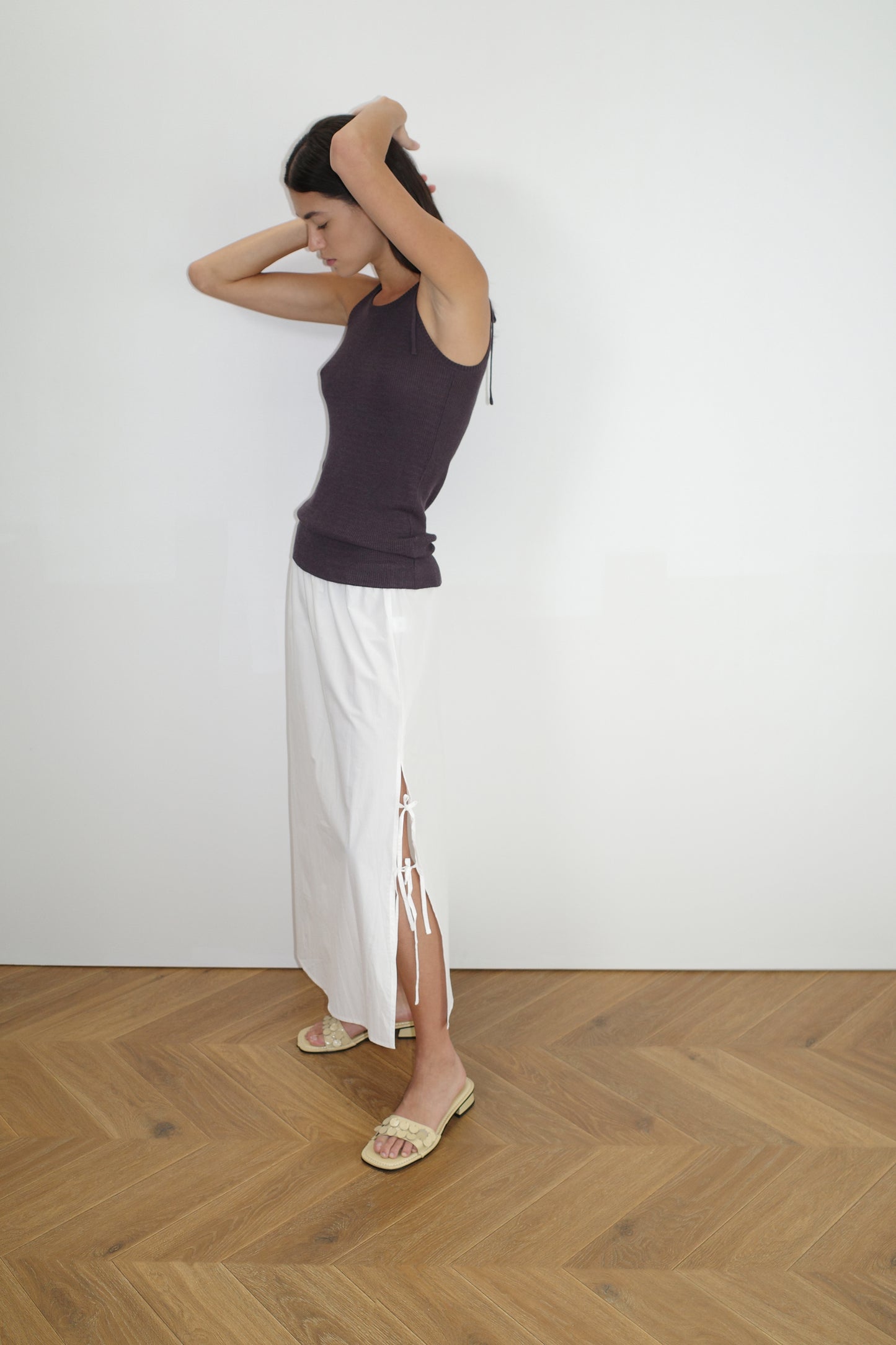 female model wears the one tie top by Deiji Studios in eggplant
a minimalist, fully fashioned tank-style knit top featuring asymmetrical tie strap design made with a lightweight ribbed texture
made from 90% eco-viscose and 10% linen
paired with a white cotton skirt