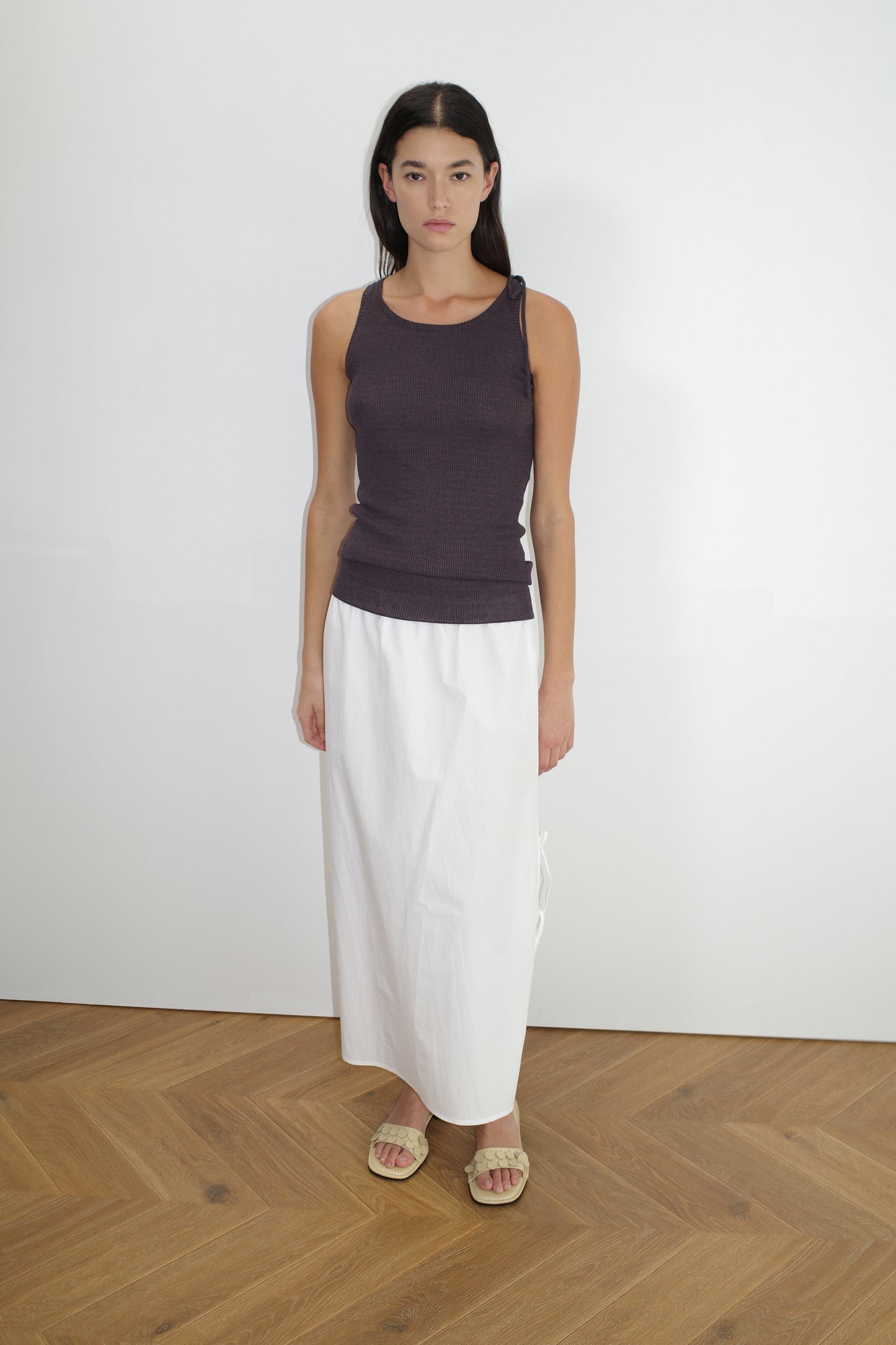 female model wears the one tie top by Deiji Studios in eggplant
a minimalist, fully fashioned tank-style knit top featuring asymmetrical tie strap design made with a lightweight ribbed texture
made from 90% eco-viscose and 10% linen
paired with a white cotton skirt