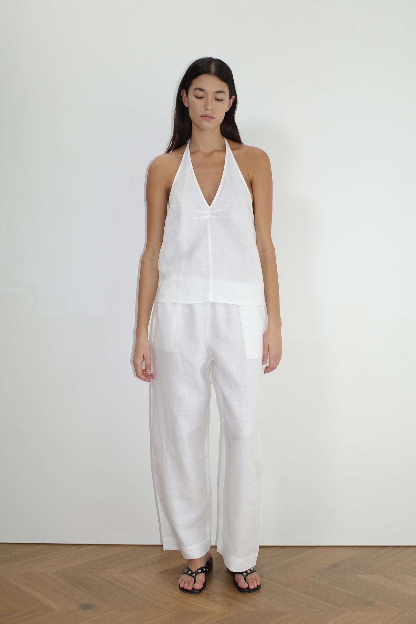 female model wears the linen ease trouser by Deiji Studios in white
the ankle length pant features a soft minimal elastic waist with side seam pockets in a straight leg
can be worn at home, in bed, or out
made from 100% GOTS certified organic, OEKO-TEX 100 certified and EU certified stone washed french linen
paired with a white linen halter top