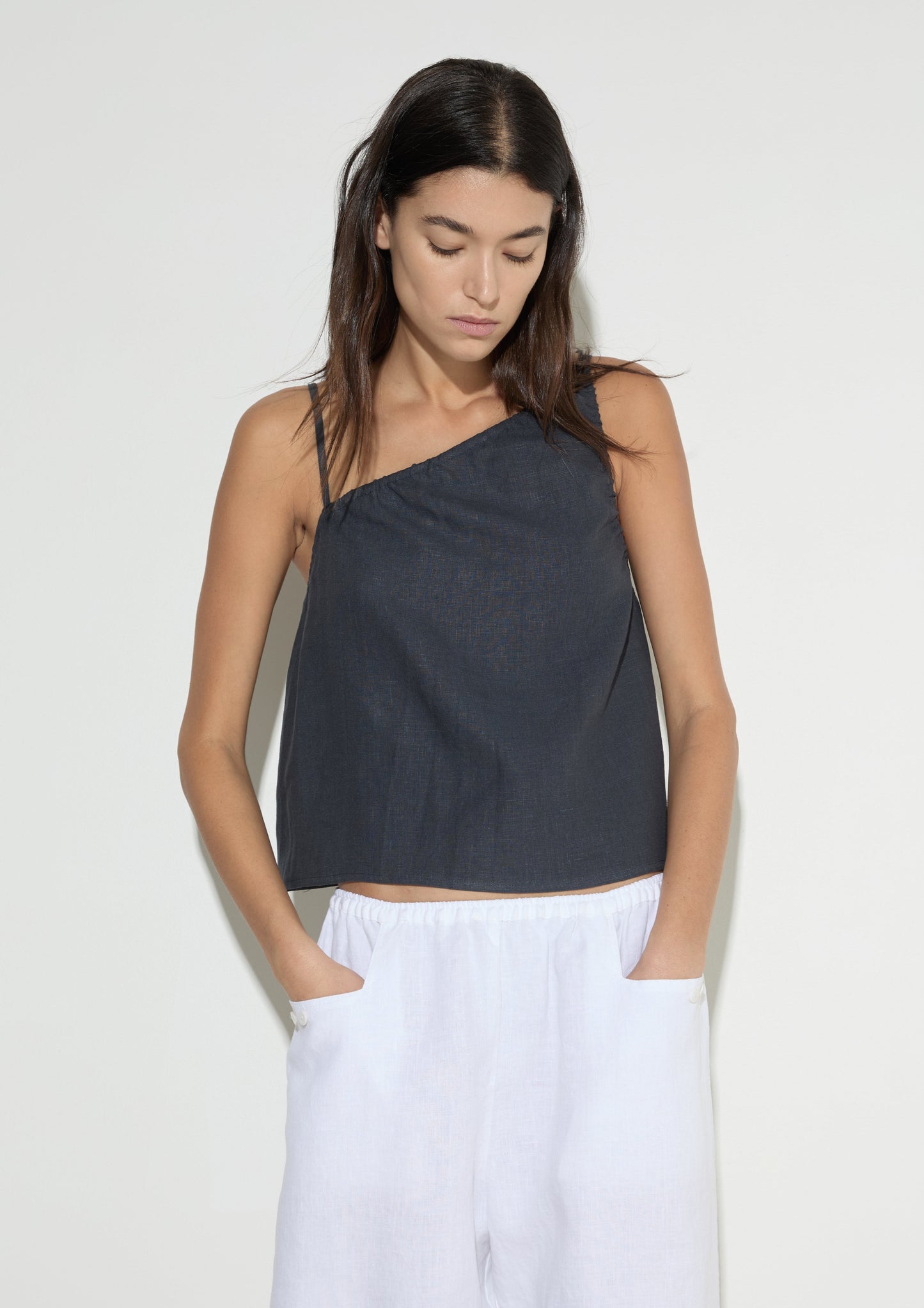 female model wears the asymmetric tie top by Deiji Studios in ink
an elevated asymmetric top with a softly gathered front neckline and elastic neckline
made from 100% GOTS certified organic, OEKO-TEX 100 certified and EU certified stone washed french linen
paired with a white cotton trouser