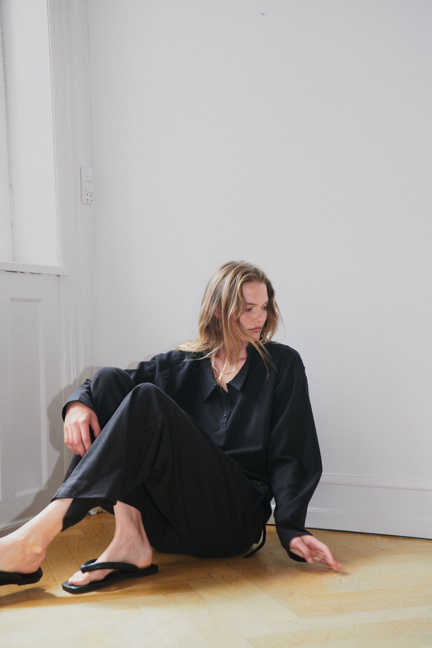 Female model wearing the jersey pant - black by Deiji Studios against plain background