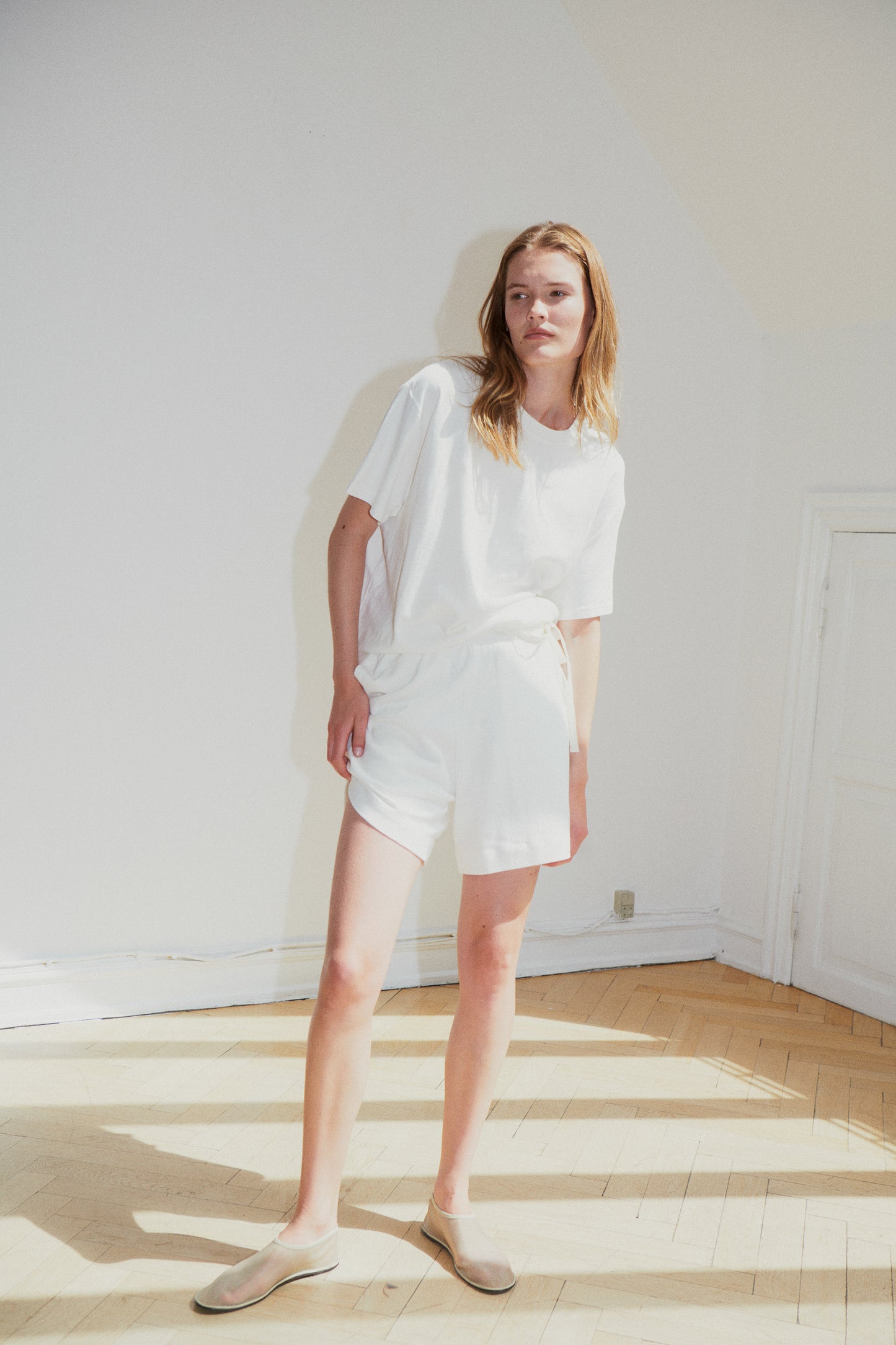 Female model wearing the jersey short - bone by Deiji Studios against plain background