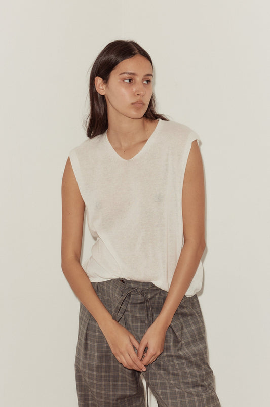 A model wears the Loose Knitted Vest - White, a sleeveless v-neck lightweight knit top, paired with grey plaid tie-waist trousers against a neutral background.