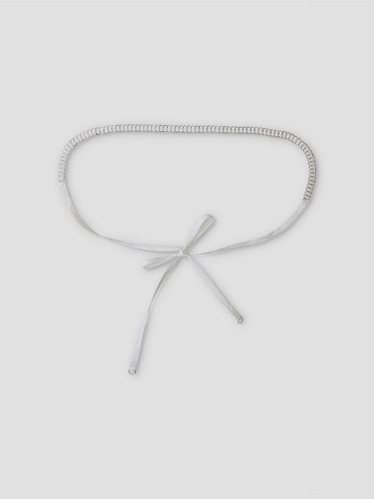 The Ring Loop Belt, featuring a silver chain and white ribbon tie closure, is shown flat on a light grey background.