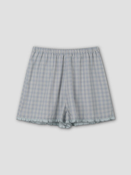 The Simple Short - Blue Check features a relaxed fit, elastic waistband, and subtle ruffle trim at the hem, shown flat on a plain light gray background.