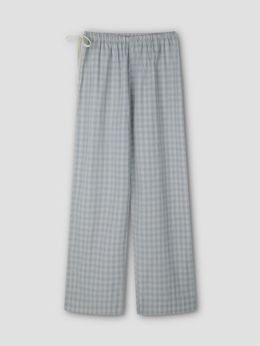 The Side Tie Pant - Blue Check features light blue and white cotton poplin checks, an elastic waistband, and a white drawstring, shown flat on a light grey background.