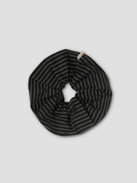 The Scrunchie - Mono Stripe features black fabric with thin white vertical stripes, shown against a light gray background.