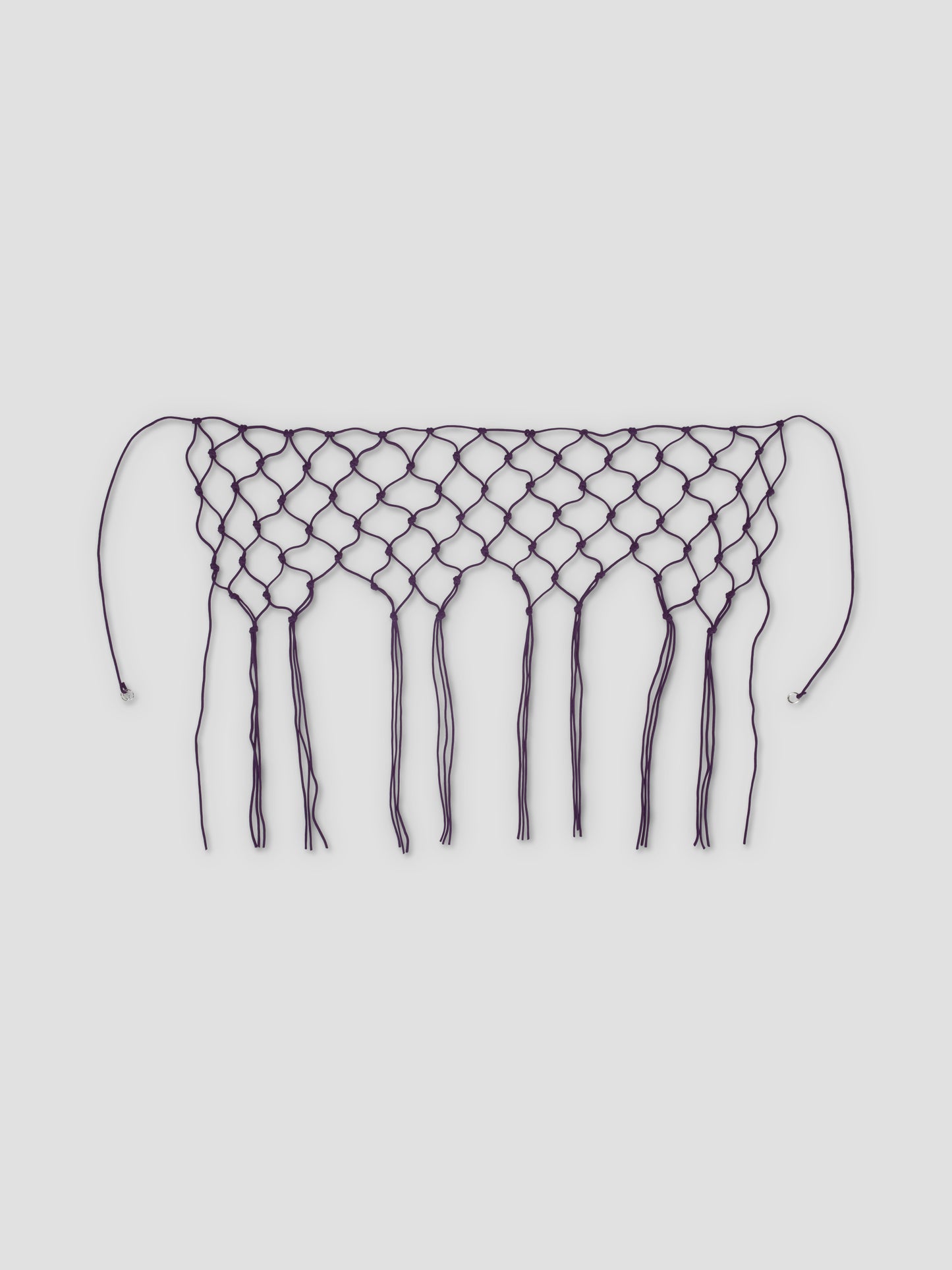 The Macrame Belt - Burgundy features a netted, diamond pattern with long fringe and two strings at each end, crafted from recycled polyester and shown on a white background.