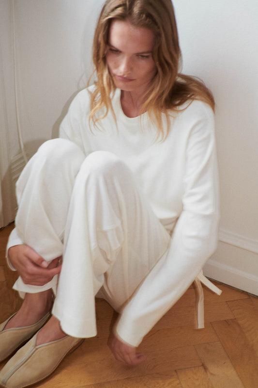 Female model wearing the jersey pant - bone by Deiji Studios against plain background
