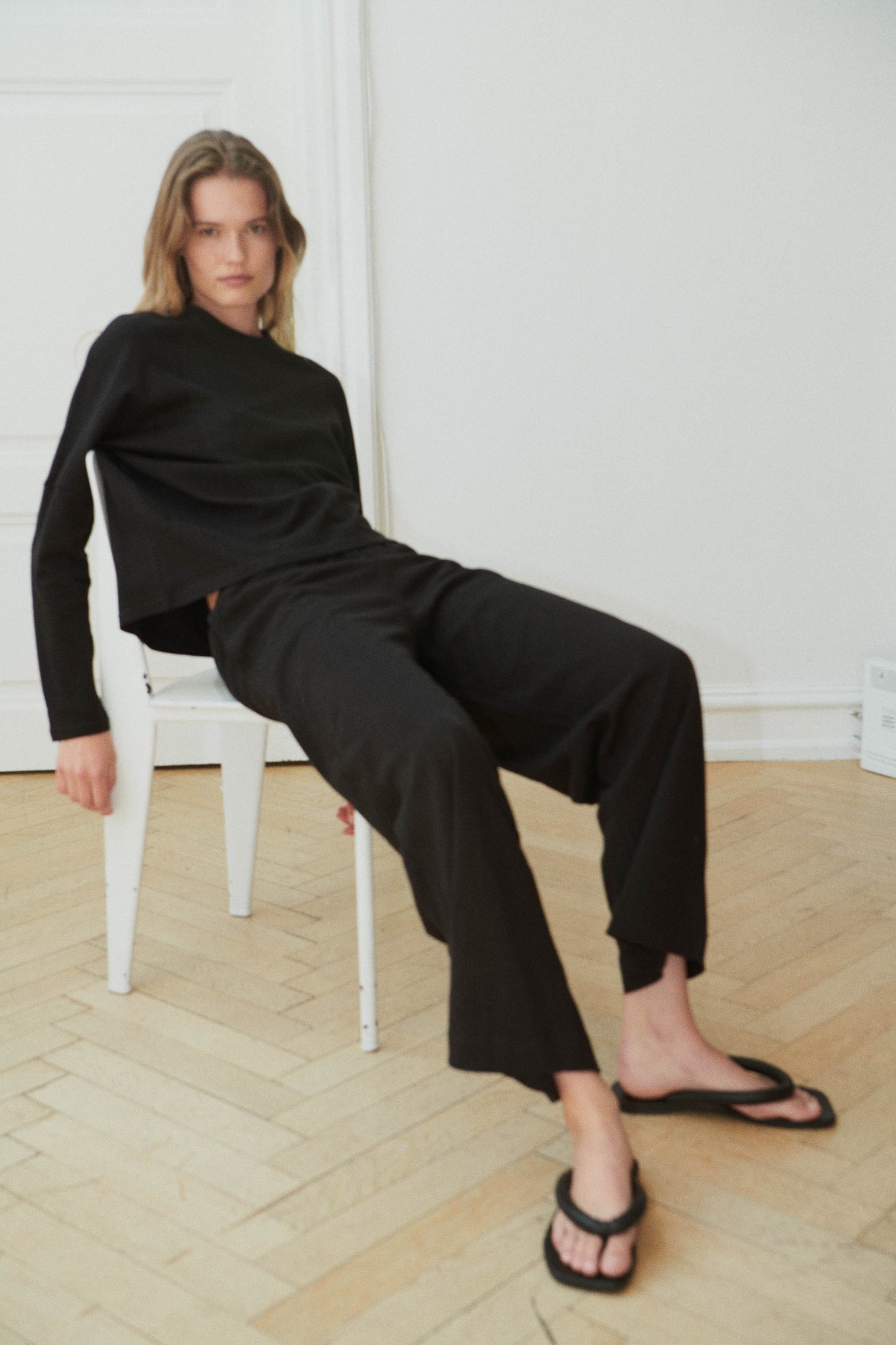Female model wearing the long sleeve jersey top - black by Deiji Studios against plain background
