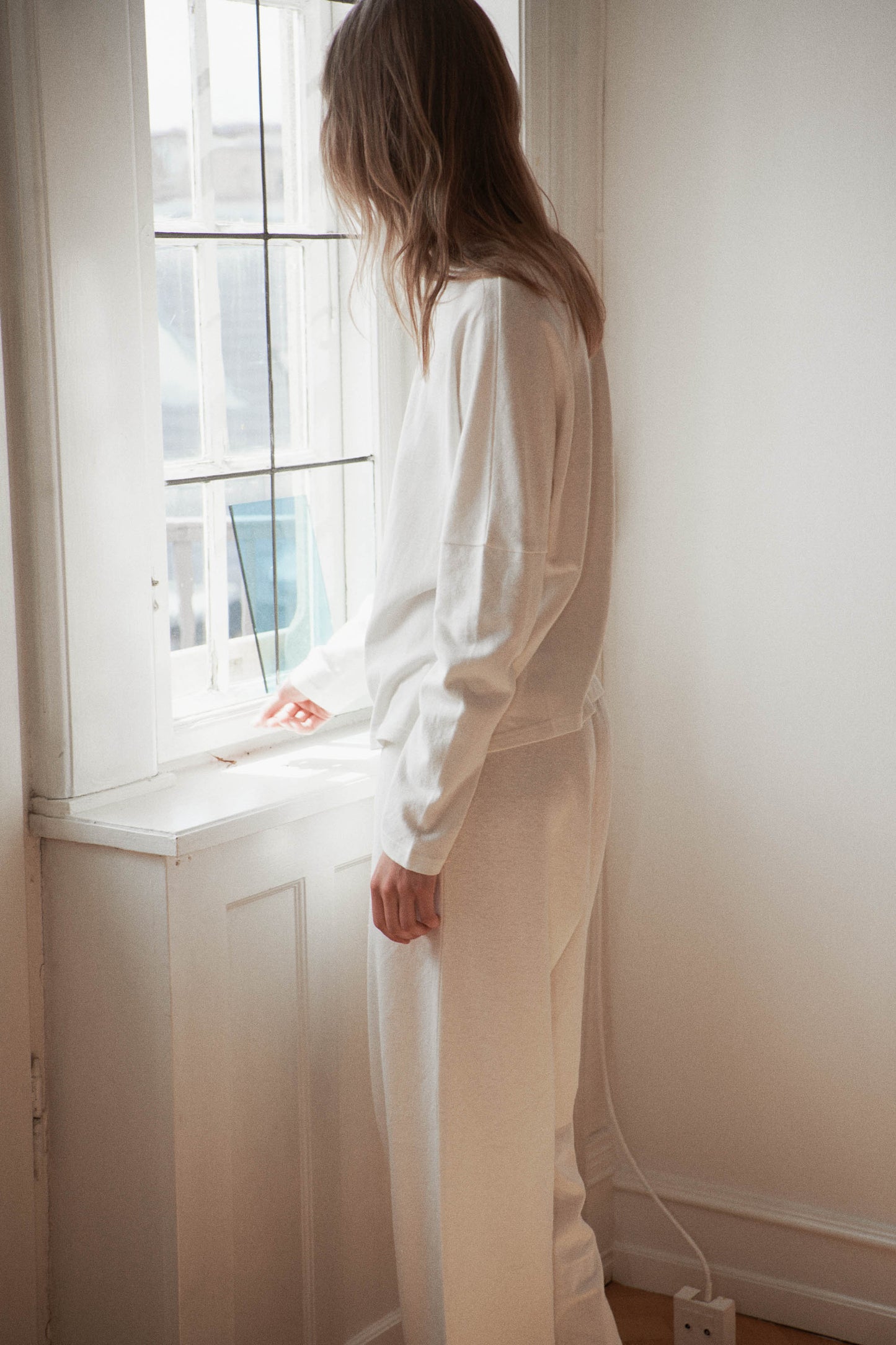 Female model wearing the jersey pant - bone by Deiji Studios against plain background