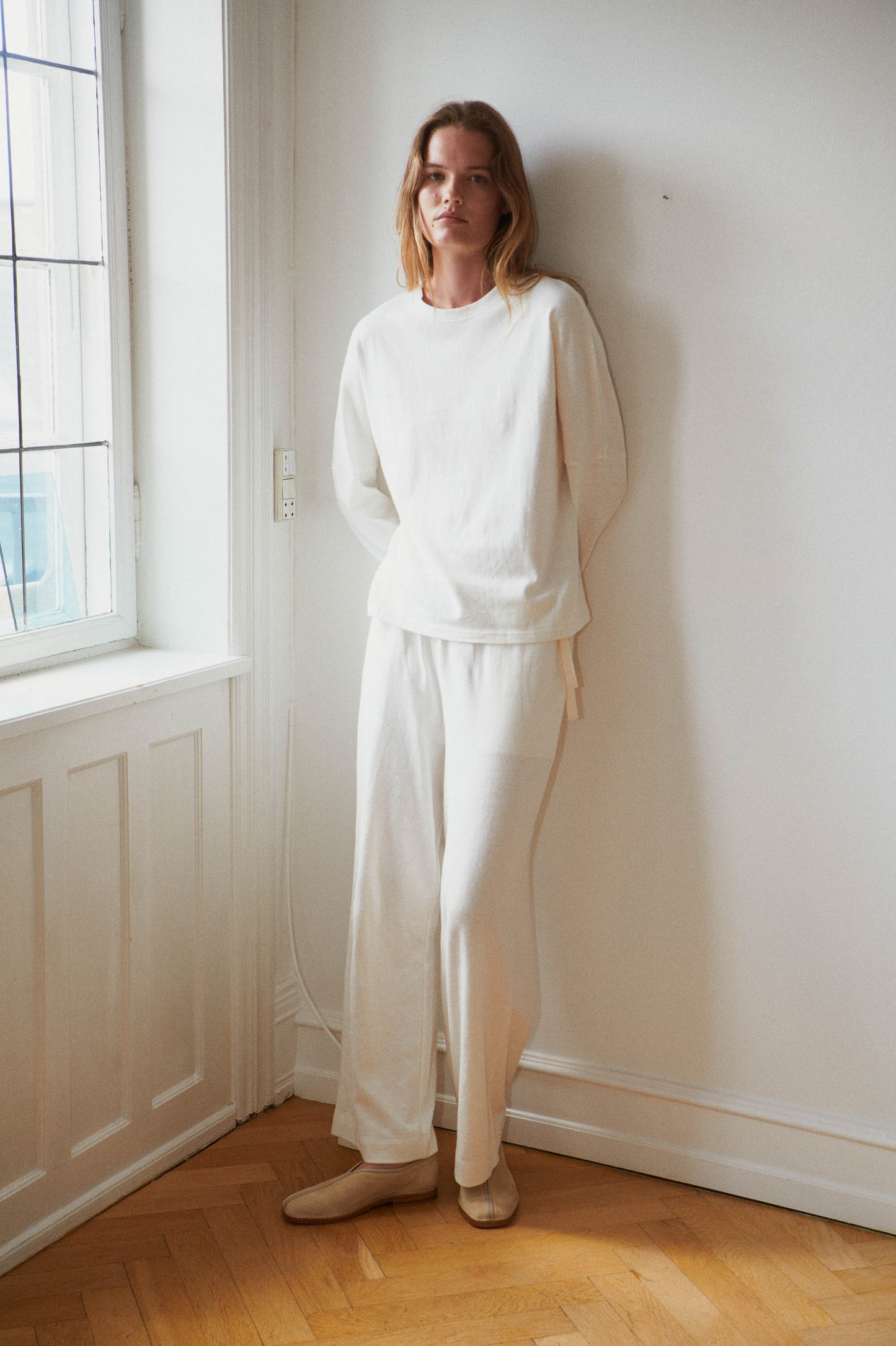 Female model wearing the jersey pant - bone by Deiji Studios against plain background
