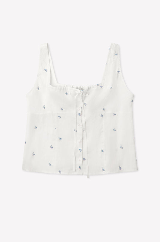 The Relax Tie Top - Floral Blue is a white linen crop tank with a square neckline, button front, blue embroidered floral pattern, and front tie detail in lightweight, textured fabric inspired by Deiji Studios.