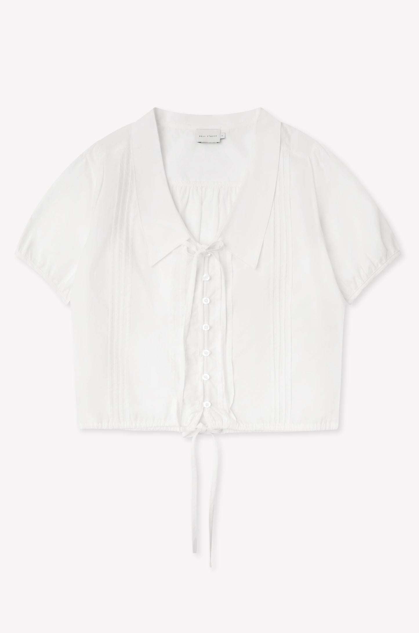 The Fine Collar Top - White features a collared v-neck, short sleeves, button-down front, pintuck details, and a waist tie—crafted from cotton poplin with signature Deiji Studios elegance.