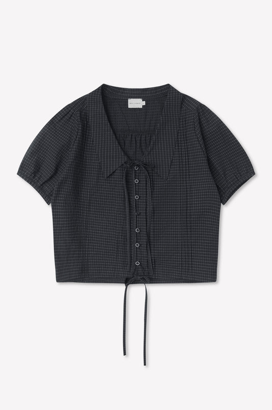 The Fine Collar Top - Mono Grid is a short-sleeved, charcoal gray cotton poplin top with a subtle grid pattern, collared v-neck, and drawstring at the cropped hem, shown laid flat on a white background.