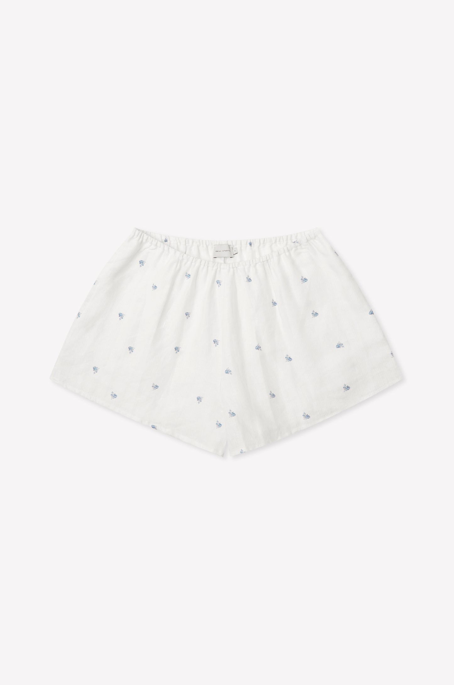 The Relax Short Set - Floral Blue features white cotton boxer shorts with a loose fit, elastic waistband, and delicate blue floral patterns, reminiscent of Deiji Studios' signature comfort, shown against a plain white background.
