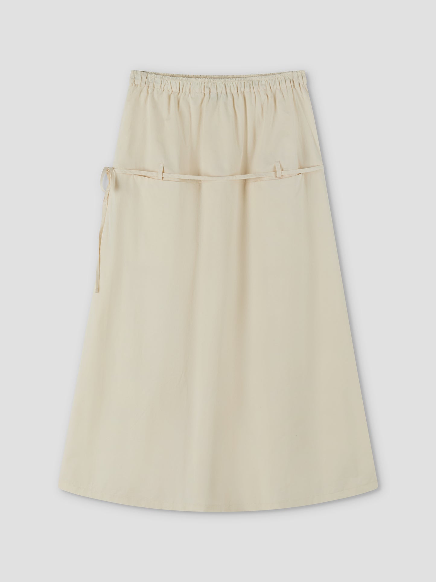 The Loop Pocket Skirt - Off White by Deiji Studios is a cream, full-length A-line skirt with an elastic waistband and two thin drawstrings at the front, crafted from lightweight fabric and displayed on a plain, light background.