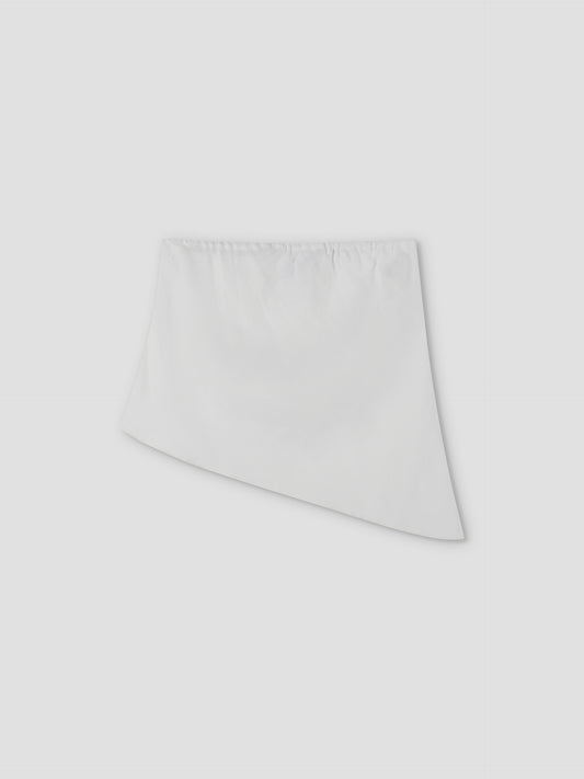 White asymmetric mini skirt by Deiji Studios featuring an elasticated waistband and a hem that's shorter on the left, longer on the right, shown on a light grey background—perfect paired with the Line Top - White.