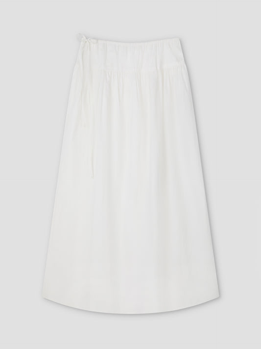 The Maxi Skirt - White Texture by Deiji Studios is a plain A-line maxi skirt with an elastic waistband and drawstring tie, shown laid flat on a light gray background.