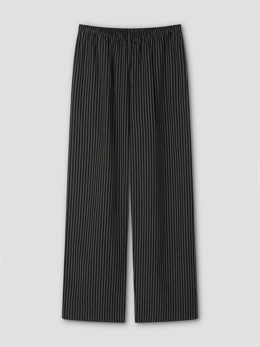 The Ease Trouser - Mono Stripe by Deiji Studios features black ankle-length design with thin white vertical pinstripes, an elastic waistband, and wide legs for a relaxed fit, shown flat on a light gray background.