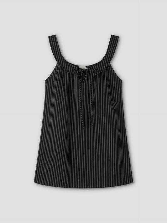 The Rounded Neck Dress - Mono stripe features a black sleeveless design with thin white vertical pinstripes, wide shoulder straps, a front tie detail, and a rounded neckline. It is displayed against a plain light gray background.