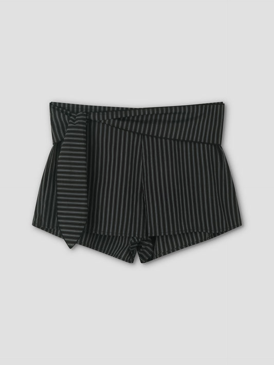 The Belted Short - Mono Stripe features black high-waisted mini shorts with thin white vertical pinstripes and a matching fabric belt tied on the left, shown against a plain light gray background.