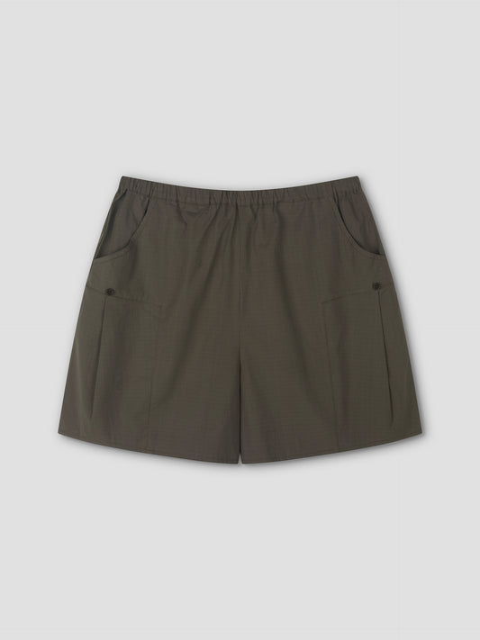 A pair of Deiji Studios Pleat Short - Khaki Check with an elastic waistband and two front pockets, laid flat on a light gray background.
