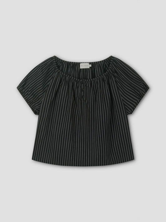 The Poplin T Shirt - Mono Stripe is a black short-sleeve blouse with white stripes, a loose fit, elastic gathered neckline, and center tie, styled like Deiji Studios. It’s displayed flat on a light gray background.