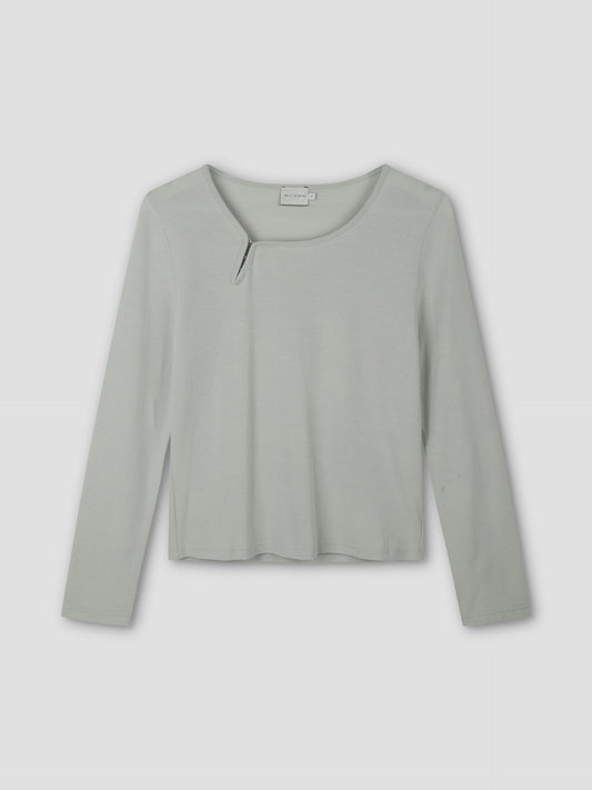 The Clasp Longsleeve - Grey Blue by Deiji Studios is a light gray-blue long-sleeve top featuring a round neckline with a small angled slit detail, shown laid flat on a plain background.