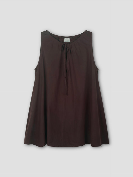 The Drawcord Dress in sepia is sleeveless and loose-fitting, with a round neckline and tie detail, featuring an A-line silhouette. Shown against a light grey background.