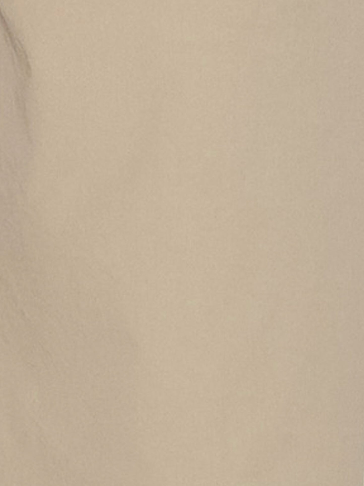 A close-up of a smooth beige surface with subtle shadows and texture, evoking the refined organic cotton featured in Deiji Studios Two Band Pant - Fawn.