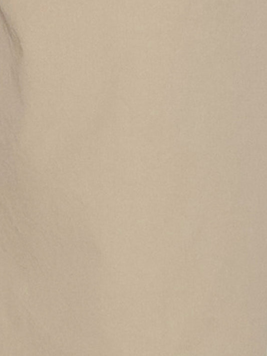 A close-up of a smooth beige surface with subtle shadows and texture, evoking the refined organic cotton featured in Deiji Studios Two Band Pant - Fawn.