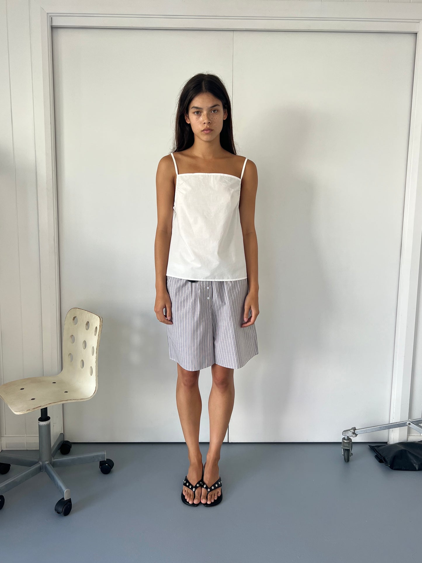 female model wears the long boxer by Deiji Studios in seas stripe
an easy pull-on boxer featuring button detail at front placket, gathered elastic waistline and deep side pockets in mid length for a relaxed fit
made from 100% GOTS certified organic cotton poplin
paired with a white cotton singlet