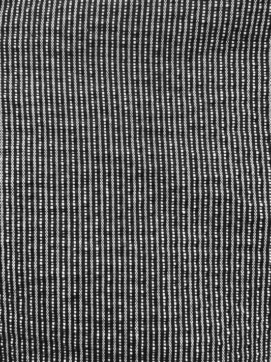 Close-up of the Exclusive Bubble Coat - Black White Stripe by 0, featuring textured black and white stripes formed by uneven dashes for a woven look—ideal for organic cotton outerwear.