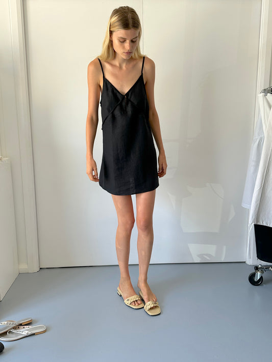 A woman in a stylish Tie Front Dress in black.