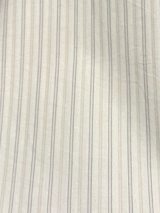 Close-up of the Button Skirt - Pacific Stripe by 0, featuring light organic cotton fabric with thin, evenly spaced vertical pinstripes in a slightly darker shade. The smooth texture shows soft wrinkles on the surface.