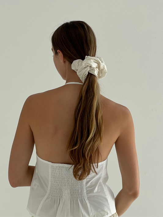 female model wears the open halter top top by Deiji Studios in white
top features open front with centre bust tie, halter neck tie and v neckline, bust seams for subtle shaping and shirred back
made from 100% GOTS certified organic cotton poplin