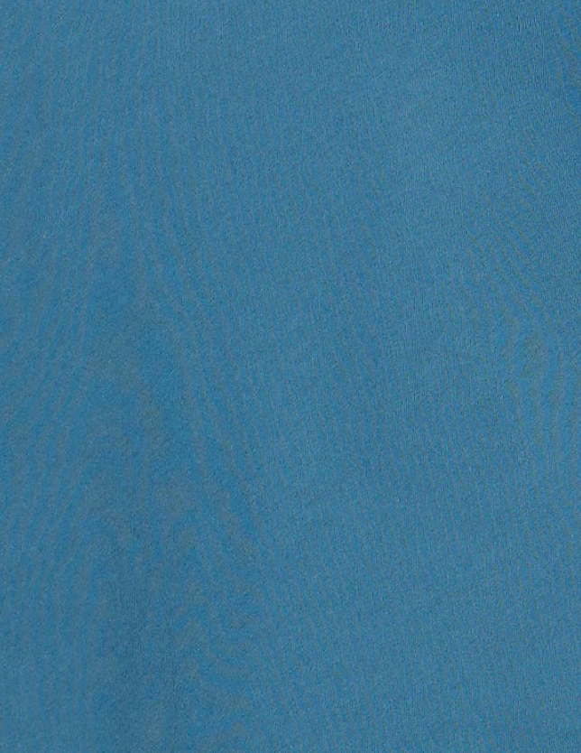Close-up of a blue fabric with a soft, slightly textured surface and subtle wavy lines visible throughout, reminiscent of the refined materials used in the Cuff Tie Top - Teal from Deiji Studios.